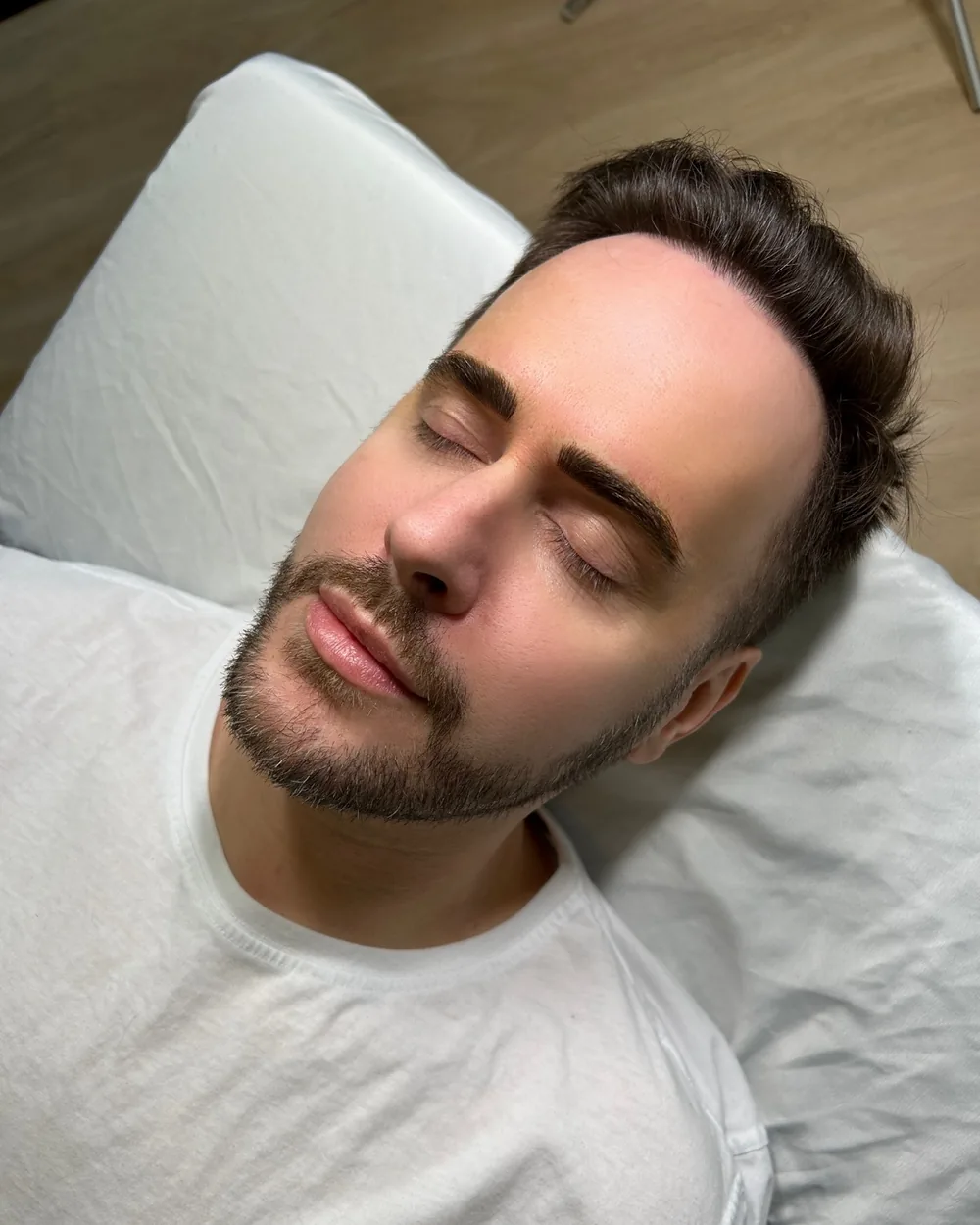 A gloved hand mapping a man's brow